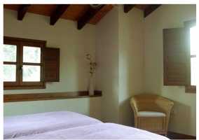 Habitación con cama de matrimonio y pared morada