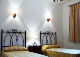 Dormitorio doble de con colchas de cuadros en tono amarillo de la casa rural