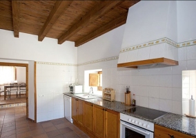 Cocina con armarios de madera y vistas del comedor