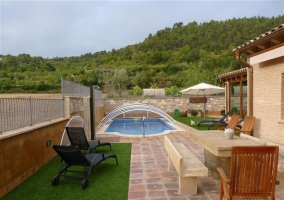 Mesa de piedra y piscina en la terraza