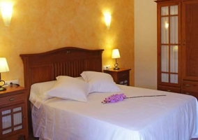 Habitación doble con cabecero de madera en la casa rural