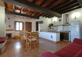 Sofá rojo, mesa y cocina