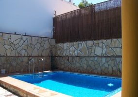 Piscina exterior con escalera y paredes de piedra