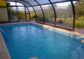 Interior de la piscina climatizada con vistas al jardín y a las montañas