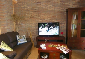 Salón con televisor sobre mueble y mesa baja delante