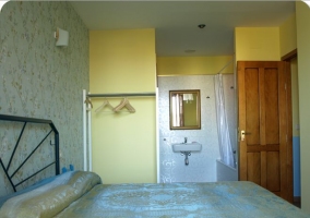 Habitación Arroyo con camas individuales y puerta de madera y ventanillas