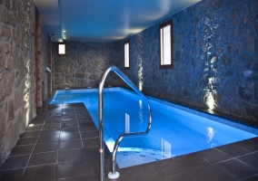 Piscina climatizada con paredes de piedra