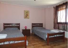 Dormitorio con vigas y cama de matrimonio de la casa rural