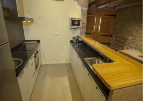 Cocina de barra americana con electrodomésticos y vigas de madera