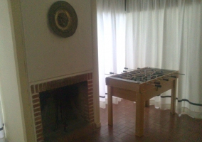 Futobolín en el salón con chimenea