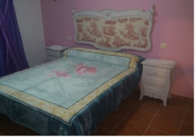 Dormitorio con cama de matrimonio y cabecero de la casa rural