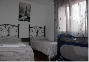 Dormitorio con dos camas de la casa rural con cuna supletoria