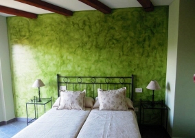 Dormitorio con 2 camas individuales y pared en verde efecto estuco