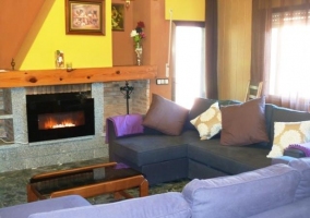 Salón con dos sillones en forma de L frente a la chimenea