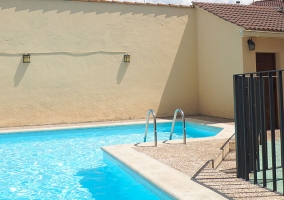 Vista desde arriba de la piscina y la terraza con mesas y sillas