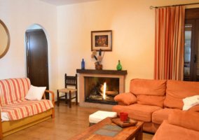 Salón con 3 sofás y una chimenea