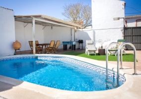 Piscina con porche y zona de solárium