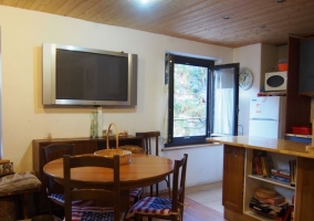 Cocina americana y comedor con una mesa de madera y sillas