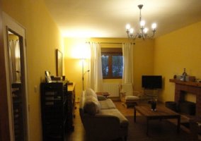 Lamparillas encendidas en el salón con sillón grande y muebles