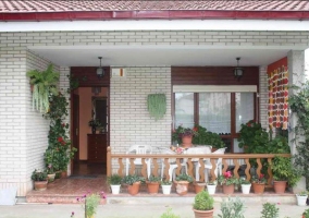 Acceso a la casa por el porche con plantas