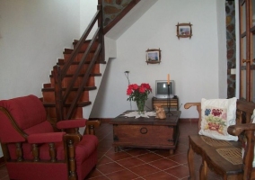 Sala de estar de la casa con televisor y una mesa en el centro