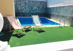 Mesa con sombrilla junto a la piscina