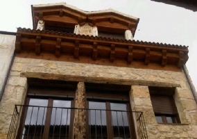 Vista de la fachada de la casa con ventanas y piedras