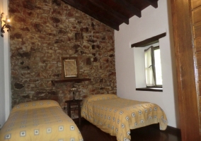 Dormitorio de matrimonio con pared de piedra