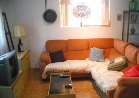 Salón comedor amueblado con cocina al fondo y barra americana