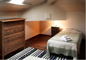 Dormitorio con dos camas individuales en la buhardilla de la casa rural