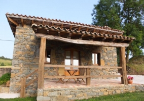 Sala de estar con sillones en burdeos y una chimenea con la tele