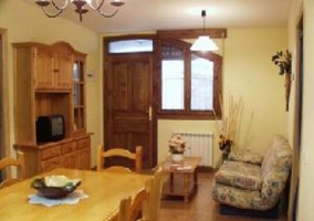 Salón comedor con mesa y sillas y cocina equipada al fondo