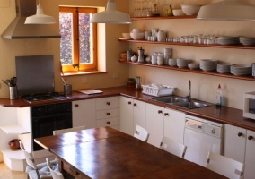 Cocina comedor con muchas sillas y mesa de madera