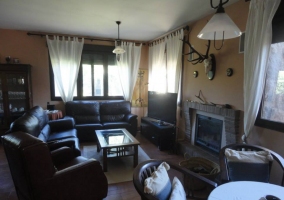 Salón con chimenea y tres sillones alrededor