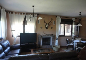 Salón con sillones frente al televisor y la chimenea