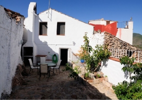 Vista completa del patio con barbacoa acompañada de mesita con sillas