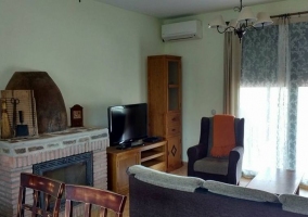 Sala de estar con chimenea y televisor de plasma